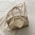 Chic beige ruched tote bag in litchi leather displayed on a matching blazer - Khaki