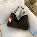 Dark brown faux leather tote bag with apple charm on a white sofa for commuting - With Pendant / Coffee