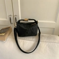 Dettaglio borsa nera in pelle testurizzata con chiusura dorata e accessori zip - Nero