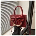 Detail of red square handbag featuring large bow and white pearl gold chain decoration - Red