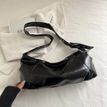 Minimalist black crescent shoulder bag with glossy leather and unique knot detail - Black