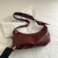 Chic burgundy underarm bag with knot strap detail on glossy faux leather surface - Red