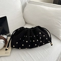 Sac seau en daim noir avec rivets dorés et cordon de serrage sur canapé blanc - Noir