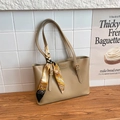 Borsa tote minimalista in pelle kaki con sciarpa elegante su base in legno - Cachi