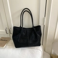 Dettaglio di una borsa tote in pelle scamosciata nera opaca con cuciture e doppi manici - Nero senza Ciondolo
