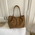 Borsa tote marrone in pelle scamosciata con doppi manici su un divano bianco - Marrone Senza Ciondolo