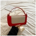 Detalle de bolso de cuero rojo con panel de lona beige y correa ancha de tejido suave - Rojo