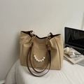 Borsa tote beige con catena di perle e doppi manici in un ambiente di lavoro elegante - Cachi