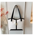 Close-up of a two-tone tote bag with crocodile texture, leather trim, and a gold metal buckle - White & Black