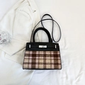 Détail d'un sac à main tendance en tissu à carreaux avec fermoir rotatif et cuir noir - Noir