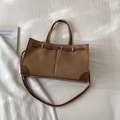 Detail of a brown woven tote bag featuring leather trim and silver metal buckle hardware - No Pendant / Brown