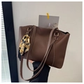 Dettaglio di una borsa tote in pelle PU marrone scuro con cuciture bianche e foulard di seta - caffè