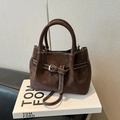Deep brown suede handbag with white contrast stitching and buckle detail on a coffee table - Coffee without Pendant