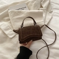 Dark brown suede-textured mini handbag with curved base and slender shoulder strap - Brown