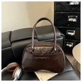 Detail of a dark brown vintage pillow bag with glossy finish and bow decoration - Dark Brown