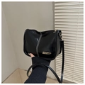 Detalle de bolso bandolera de charol negro con costuras blancas y logotipo metálico dorado - Negro