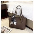 Detailopname van de donkerbruine leren shopper met een decoratieve zijden sjaal als accent - koffiekleur