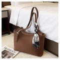 Detail van een bruine leren shopper tas met een zijden sjaal aan het handvat - Bruin