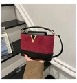 Detail of red quilted suede bucket bag with black leather trim and golden V logo - Red