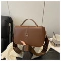 Detail of caramel brown leather handbag with gold geometric lock and wide nylon strap - Brown