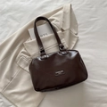 Borsa tote vintage in pelle PU marrone scuro con manico e etichetta su sfondo di tessuto - Marrone