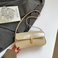 Chic beige glossy leather baguette bag with a golden metal twist lock and slim strap - Khaki