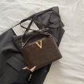 Bolso cubo de ante marrón oscuro con detalle en V dorado sobre blazer - Marrón