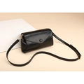 Minimalistische schwarze glänzende Ledertasche mit goldener Hardware auf Ästhetik-Hintergrund - Schwarz