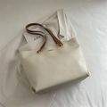 Minimalist cream tote bag with brown leather straps and gold logo on white blazer - White