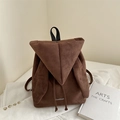 Brown suede backpack with rabbit ear design and white fashion text on corduroy background - Brown