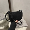 Bolso de hombro media luna negro mate minimalista con cremallera plateada en superficie blanca - Negro
