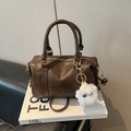 Sac Boston plissé marron avec poignées, bandoulière et un charmant petit monstre en peluche - Marron avec Pendentif