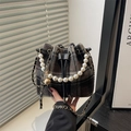 Bolso cubo de cuadros con asa de perlas y colgante de bola de metal en ambiente real - Negro