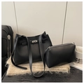 Detalle de un conjunto de bolsos de cuero negro con hebilla estilo Kelly sobre una bufanda - Negro