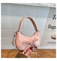 Detailansicht der rosa glänzenden Halbmond-Tasche mit Schleife und silbernen Kugeln - Rosa