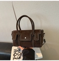 Détail du sac à main en cuir marron foncé avec surpiqûres et bandoulière réglable - café