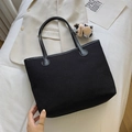 Minimalist black canvas tote bag for women with a cute cow plush pendant charm - Black