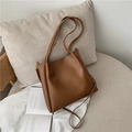 Brown minimalist matte leather tote bag with slim handles in a lifestyle setting - Brown