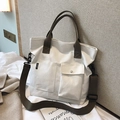 White canvas tote bag with brown straps and sport label in a cozy home setting - White