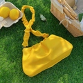 Borsa a nuvola plissettata giallo brillante con tracolla arricciata in un prato - Verde