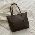 Dunkelbraune Oversize-Shopper mit verstellbaren Gold-Schnallen auf weißem Stoff - Kaffeebraun