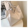 Close-up of cream white PU leather tote bag with silver metal ring and soft texture - Off White