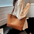 Grande borsa tote in paglia con manici in finta pelle marrone indossata da una modella - Cuoio