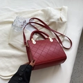 Burgundy quilted crossbody bag with woven handle and gold fashion lettering detail - Red