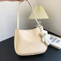 Creamy beige PU leather hobo bag with plush bear charm in a minimalist studio setting - With Pendant / Off White