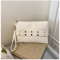 Detail view of a white leather envelope clutch with golden hexagonal rivets and wristlet - White