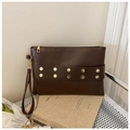Detail of dark brown envelope clutch with golden hexagonal rivets and metal zipper - Brown