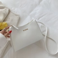 Elegante borsa a tracolla in pelle bianca con logo dorato su letto bianco - Bianco
