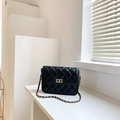 Elegant black quilted crossbody bag with gold chain strap on minimalist white background - Black