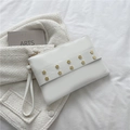Pochette bianca minimalista in pelle con rivetti esagonali dorati e cinturino da polso - Bianco